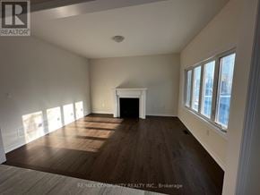 Oshawa (Eastdale) apartment for rent - A large, empty room with wood flooring and a fireplace.