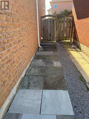 Richmond Hill (Rouge Woods) apartment for rent - A brick wall with a gate and a stone pathway.