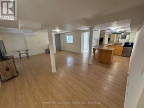 Richmond Hill (Rouge Woods) apartment for rent - A spacious room with wooden flooring and white walls.