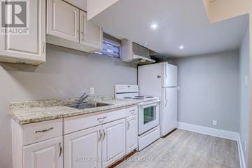 Oshawa (Donevan) apartment for rent - A kitchen with white cabinets and a granite countertop.
