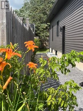 Russell apartment for rent - A house with a fence and flowers in front.