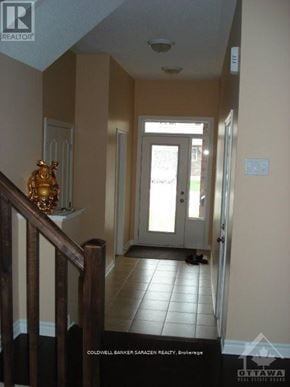 Ottawa townhouse for rent - A hallway with a statue on the banister and a door at the end.