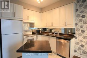 Toronto (Bay Street Corridor) condo for rent - A kitchen with white cabinets and a black counter top.