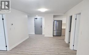 Windsor condo for rent - A spacious room with a door and a refrigerator in the background.