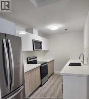 Windsor condo for rent - A kitchen with a refrigerator, microwave, oven, sink and countertop.