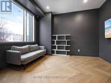 Toronto (Bayview Village) townhouse for rent - A living room with a grey couch and a wooden floor.