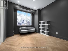 Toronto (Bayview Village) townhouse for rent - A living room with a grey couch and a wooden floor.