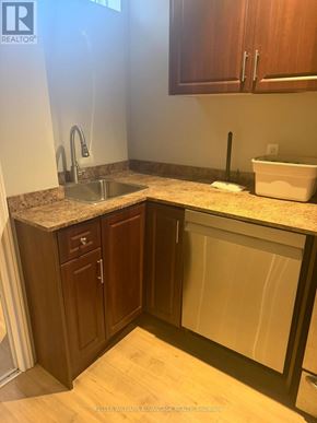 Vaughan (Vellore Village) apartment for rent - A kitchen with brown cabinets and a granite countertop.