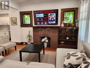 Niagara Falls (Cherrywood) apartment for rent - A living room with a fireplace and a flat screen TV mounted above it.