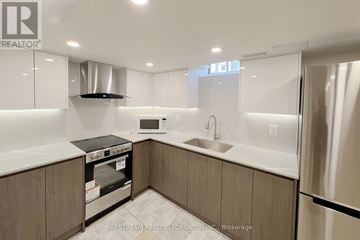 Richmond Hill townhouse for rent - A modern kitchen with a stove top oven and a microwave.