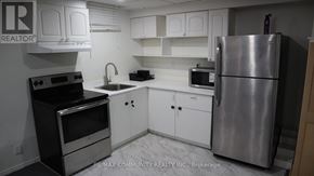 Pickering (Brock Ridge) apartment for rent - A kitchen with white cabinets and a stainless steel refrigerator.
