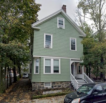 Boston apartment for rent - A green house with a white door and windows.