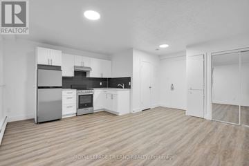 London South (South F) multi-family for rent - A spacious kitchen with white cabinets and stainless steel appliances.