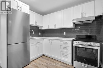 London South (South F) multi-family for rent - A modern kitchen with white cabinets and a stainless steel refrigerator.