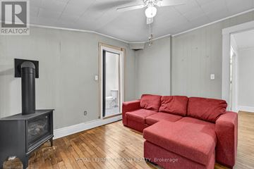 St. Thomas duplex for rent - A living room with a red couch and a wood burning stove.