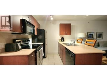 Vancouver apartment for rent - A kitchen with a sink, microwave, oven and fridge.