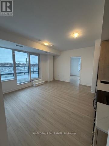 Toronto (Rouge) condo for rent - A spacious room with wooden flooring and large windows.