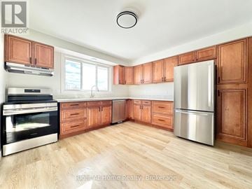 Hamilton apartment for rent - A kitchen with wooden cabinets and a stainless steel refrigerator.