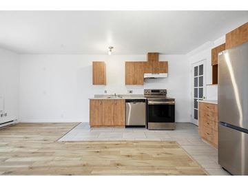 Gatineau (Hull) condo for rent - A kitchen with wooden floors and stainless steel appliances.