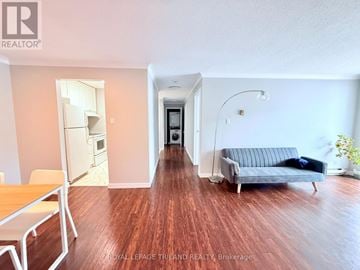London South (South T) condo for rent - A living room with a grey couch and a wooden floor.