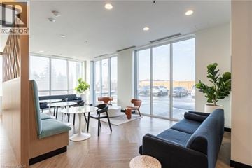 Kitchener condo for rent - A living room with a blue couch and a wooden chair.