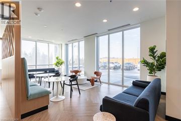 Kitchener condo for rent - A living room with a blue couch and a wooden chair.