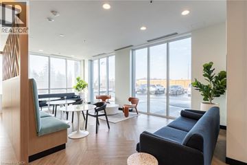 Kitchener condo for rent - A living room with a blue couch and a wooden chair.