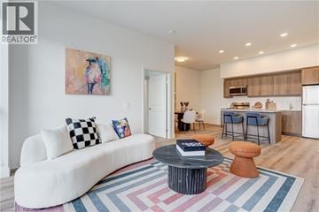 Kitchener condo for rent - A living room with a white couch and a painting on the wall.