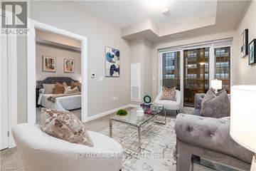 Guelph (St. Patrick's Ward) condo for rent - A living room with a grey couch and a glass coffee table.