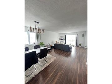 Gatineau (Aylmer) condo for rent - A living room with a grey couch and a wooden floor.