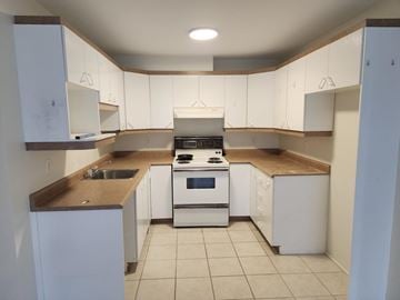 Gatineau (Hull) condo for rent - A kitchen with white cabinets and a stove top oven.