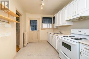 Ottawa multi-family for rent - A kitchen with white appliances and cabinets.