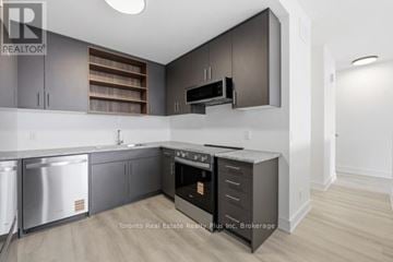 St. Catharines (Oakdale) townhouse for rent - A modern kitchen with dark wood cabinets and stainless steel appliances.