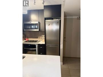 Vancouver apartment for rent - A kitchen with a stainless steel refrigerator and a white counter.