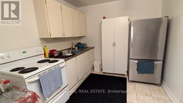 Toronto (Thistletown-Beaumonde Heights) apartment for rent - A kitchen with white appliances and cabinets.