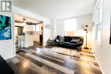 Central Elgin (Port Stanley) apartment for rent - A living room with a black couch and a wooden floor.
