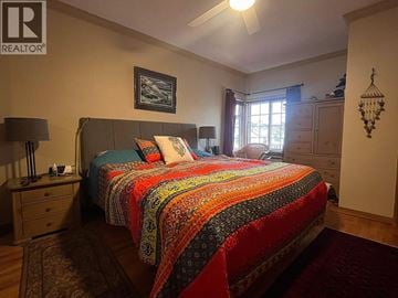 Vancouver apartment for rent - A bedroom with a bed covered in a multicolored quilt.