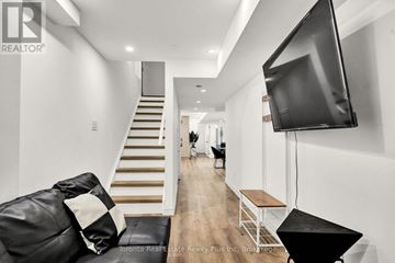 Markham (Cedarwood) apartment for rent - A living room with a black leather couch and a television.