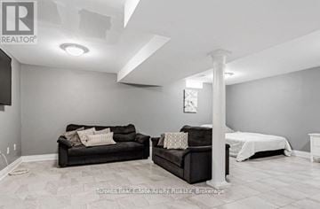 New Tecumseth (Alliston) apartment for rent - A living room with a black couch and a white bed.