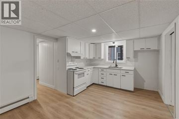 Sarnia apartment for rent - A white kitchen with wooden floors and white cabinets.