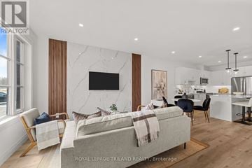 London North (North E) townhouse for rent - A modern living room with a grey sofa and a television on the wall.