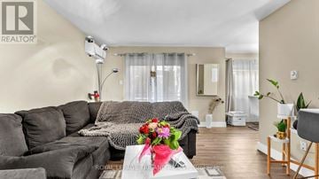 London South (South F) multi-family for rent - A living room with a grey sofa and a coffee table with a vase of flowers on it.
