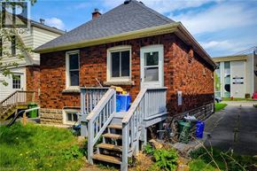 Hamilton apartment for rent - A red brick house with a grey staircase leading to the front door.