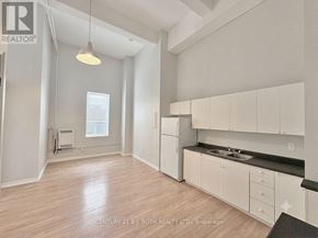 Barrie (City Centre) multi-family for rent - A well-lit, spacious kitchen with white cabinets and a black countertop.
