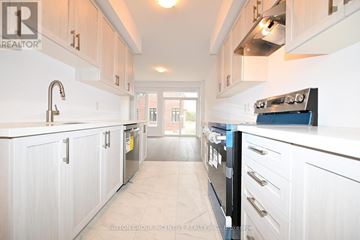 Barrie apartment for rent - A kitchen with white cabinets and a black stove top oven.