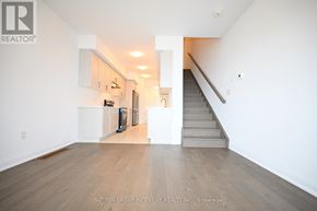 Barrie apartment for rent - A spacious room with a staircase leading to the upper floor.