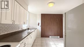 London East (East F) multi-family for rent - A kitchen with white cabinets and a brown countertop.