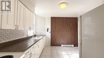London East (East F) multi-family for rent - A kitchen with white cabinets and a brown countertop.