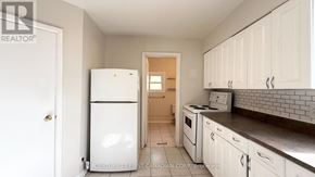 London East (East F) multi-family for rent - A white refrigerator is in a kitchen with white cabinets.