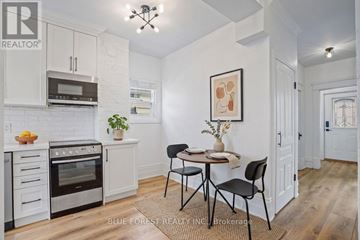 London East (East F) multi-family for rent - A kitchen with white cabinets and a dining table set for two.